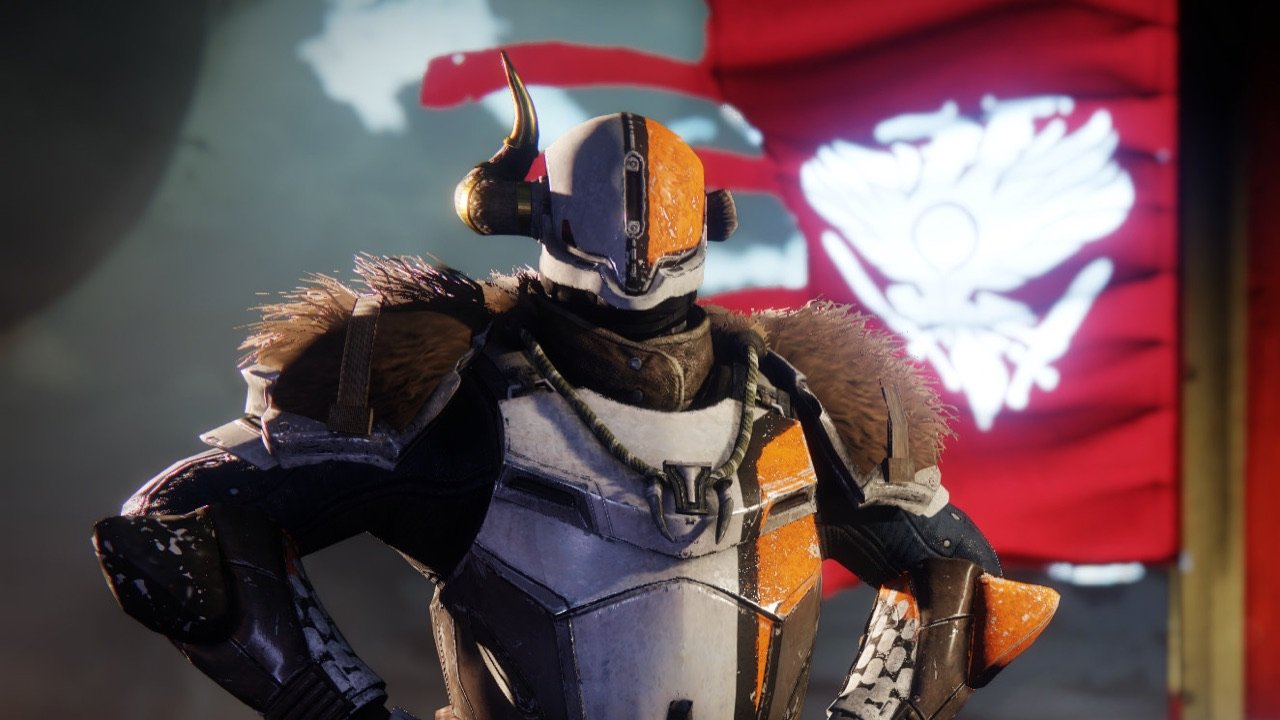 Lord Shaxx, Destiny 2's Crucible handler, in orange-and-white armor in front of a red Crucible banner.
